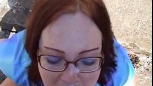 Cute nerd gives blowjob outdoors