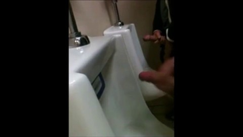 two slim dicks getting wanked at the urinals