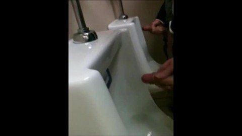 two slim dicks getting wanked at the urinals