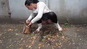 Russian woman pissing near the garages